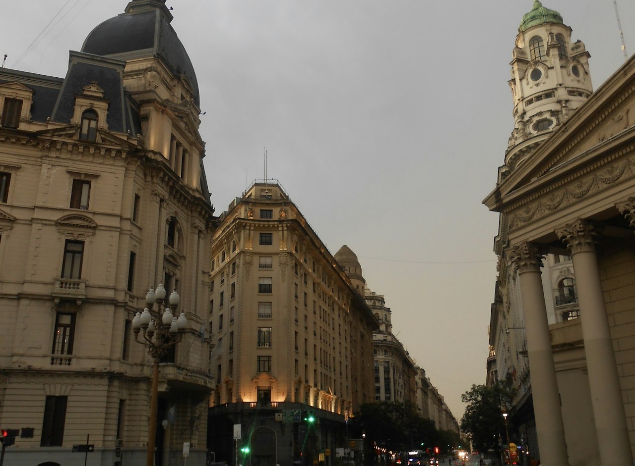 Ornate buildings line a city street at dusk