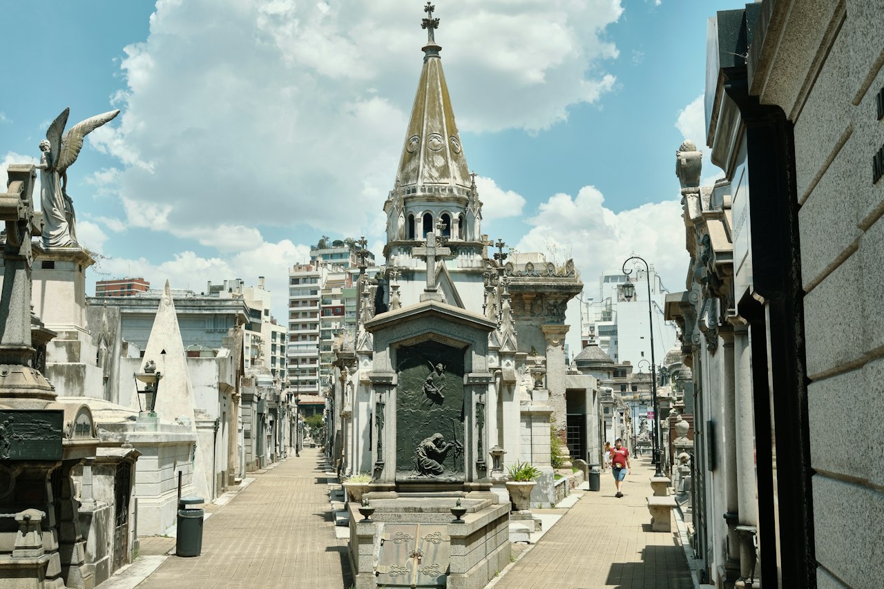 Grand cemetery with ornate mausoleums and a tall spire