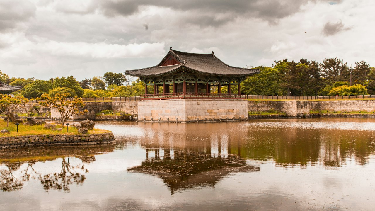 a pond with a pavilion in the middle of it