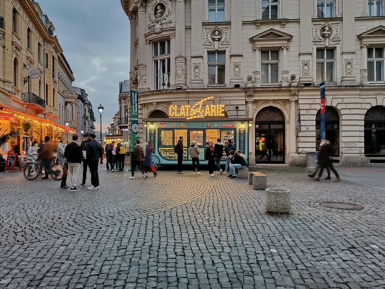a group of people walking around a cobblestone street