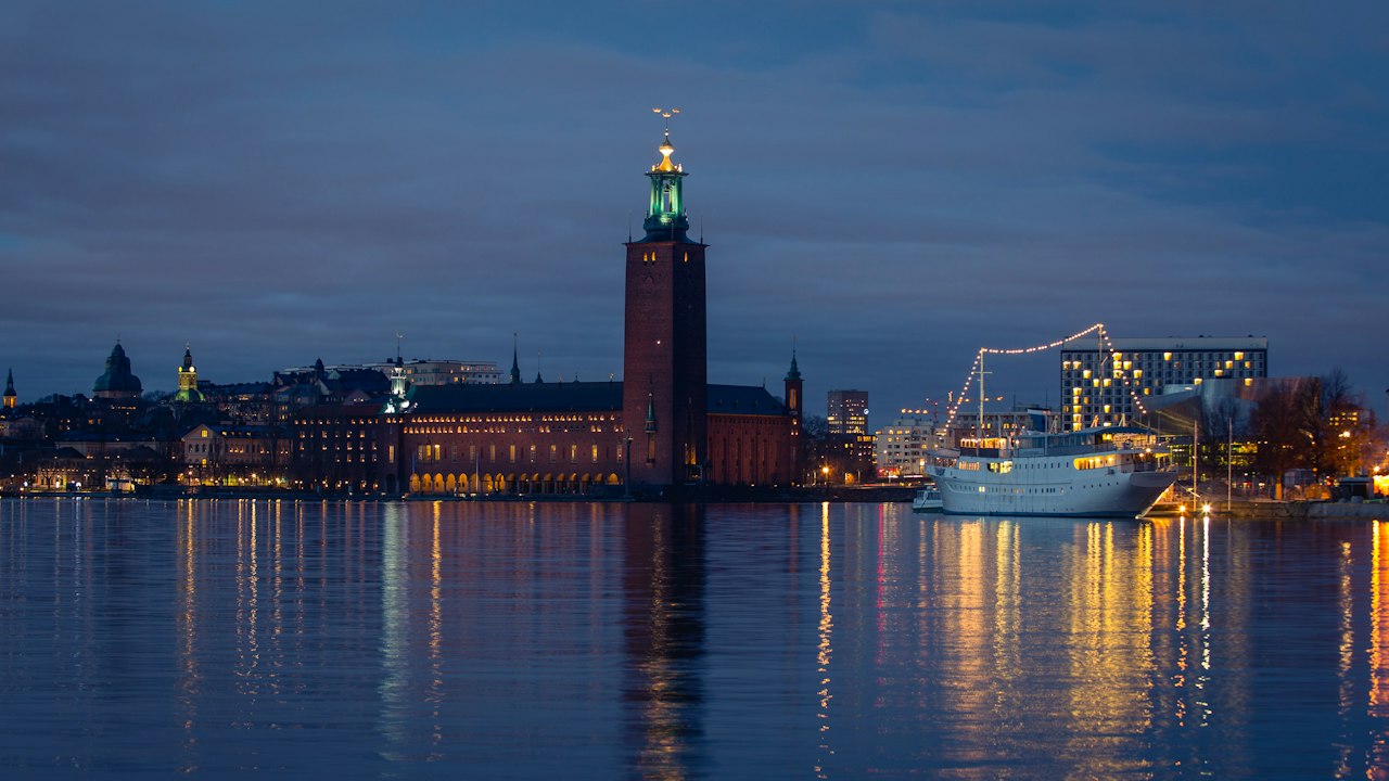 a large building with a clock tower next to a body of water