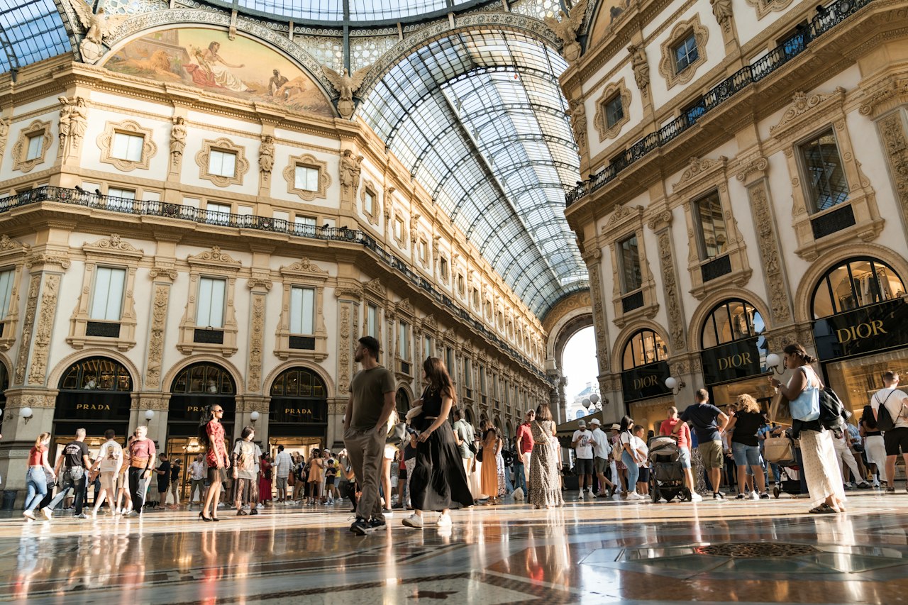 People walking inside a grand shopping arcade with glass ceiling