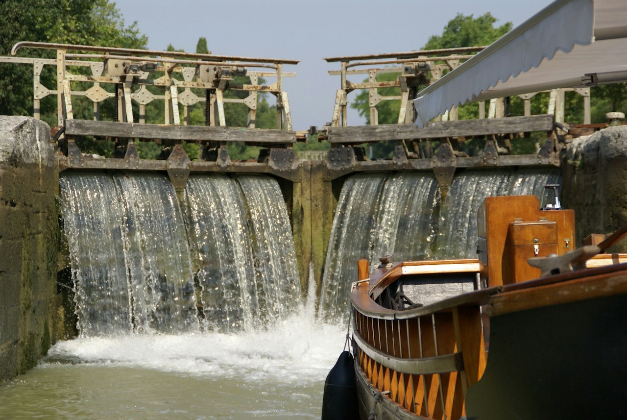 Boat passing through a canal lock with water flowing